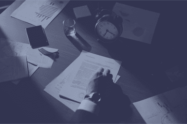 Documents and clock on desk representing deadline